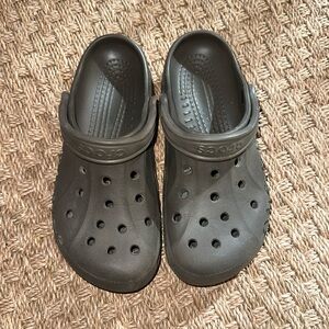 Brown/grayish women’s size 9 crocs/ men’s size 7 crocs.